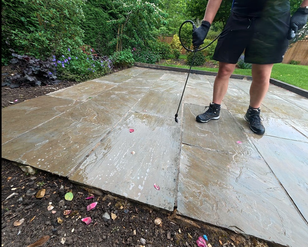 Technician applying Regrowth Protection treatment to a stone patio